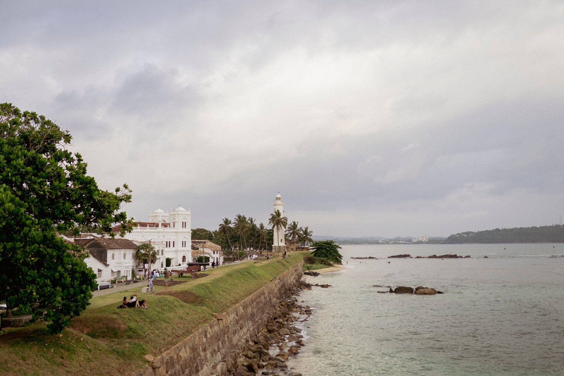 The ramparts of Galle Fort running along the Indian Ocean, with the lighthouse and the white buildings of the old town
