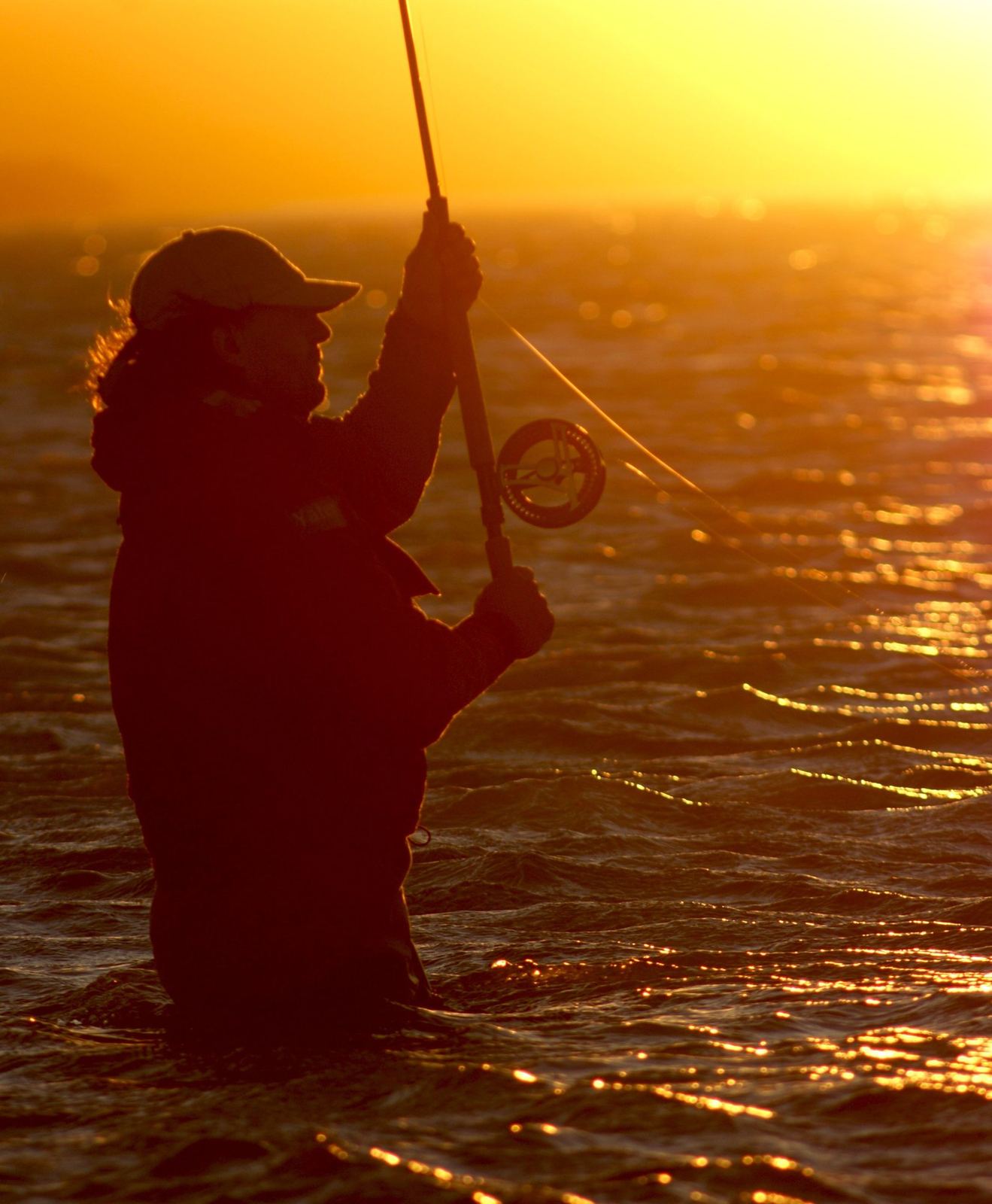 A fly fisher at sunset