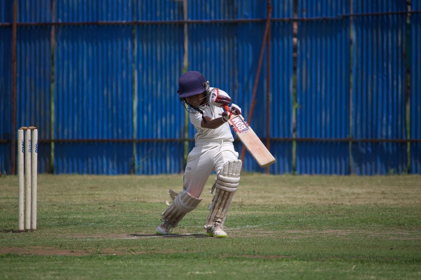 A young batter playing a drive