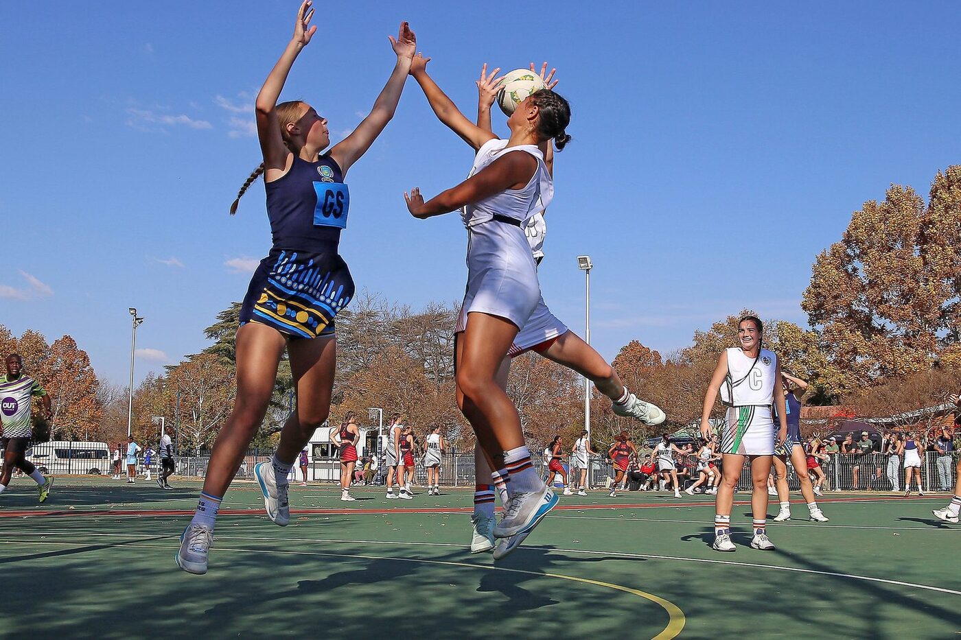 Two netballers leaping for the ball